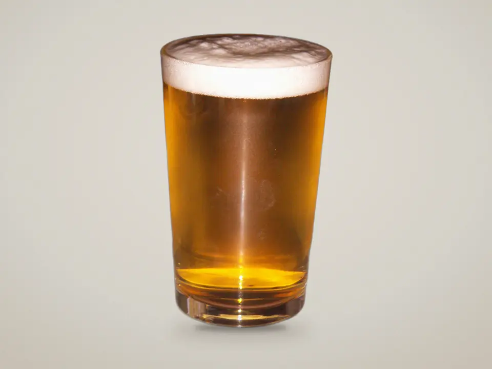 Bière blonde pression avec sa mousse dans un verre